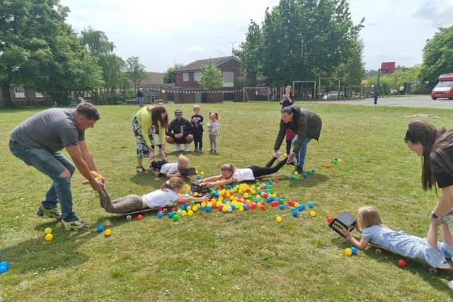 Visitors playing a game of 'Human Hungry Hippos' on the field.