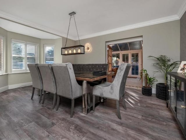 The first reception room we look at is this delightful dining room, which is a good size. It has a Karndean floor, coving to the ceiling, a bay with sash windows facing the front of the property and connecting double doors through to the conservatory.