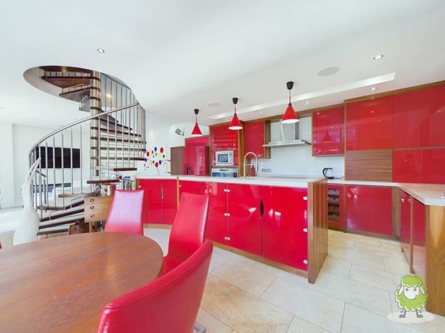 As we step inside the remarkable home, we find that the ground floor is dominated by a warm and inviting open-plan living, dining and kitchen space. The kitchen section is fitted with premium appliances.