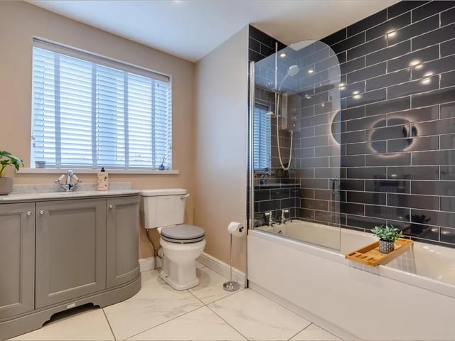 The perfect place to unwind, the bathroom features a contemporary three piece white suite comprising a panelled bath with Mira electric shower over. Vanity unit with inset wash hand basin with mixer tap, marble style quartz worktops and storage cupboards beneath. Low flush WC. Tiled floor, five ceiling spotlights, extractor fan and obscure double glazed window to the rear elevation.