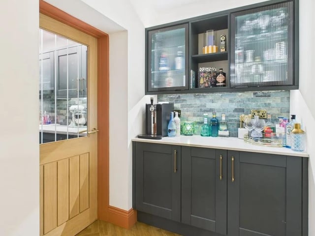 A dedicated bar area to a side lobby leads to a spacious utility room.