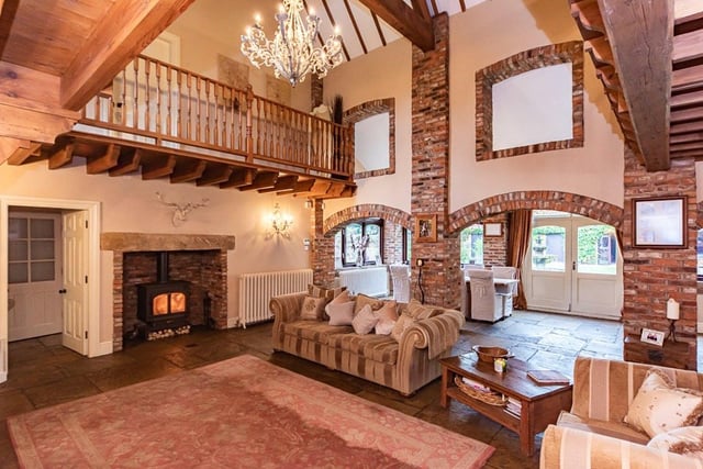 The living area has a vaulted roof with wooden beams, a "stunning" fireplace and a balcony gallery.
