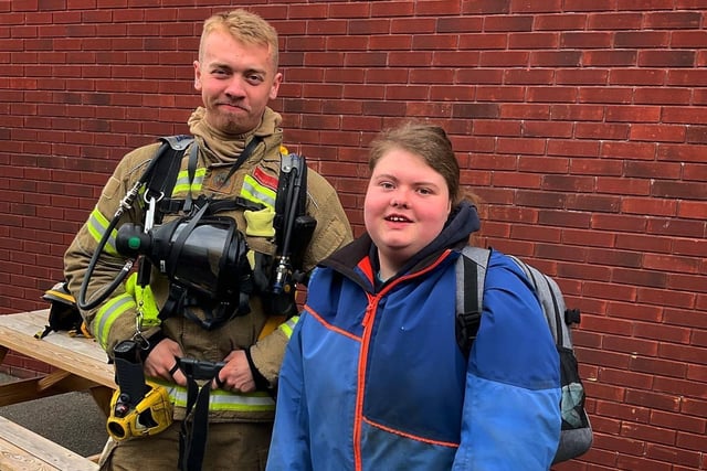 A Shirebrook firefighter poses with a pupil at Stubbin Wood School.