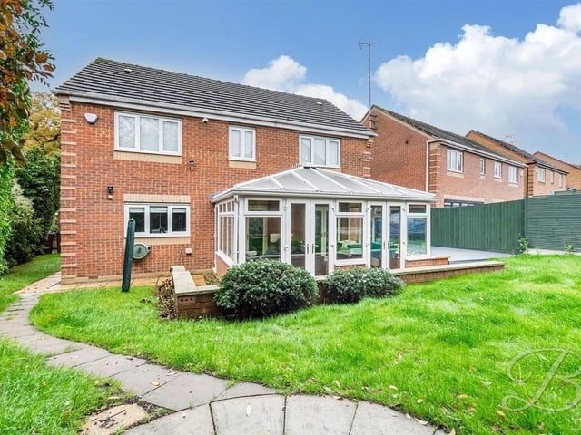 The garden features a lawn and a large patio suitable for seating.