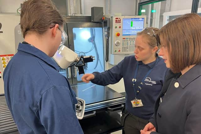 Engineering technician and advanced apprentice Sasha Jephson, centre, demonstrates a Haas Automation CNC machine to the shadow education secretary, joined by manufacturing engineering student Josh Lyons.