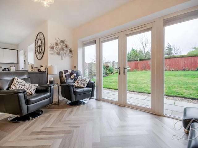 The open plan kitchen/dining/living space is bright and airy with patio doors leading onto the garden.