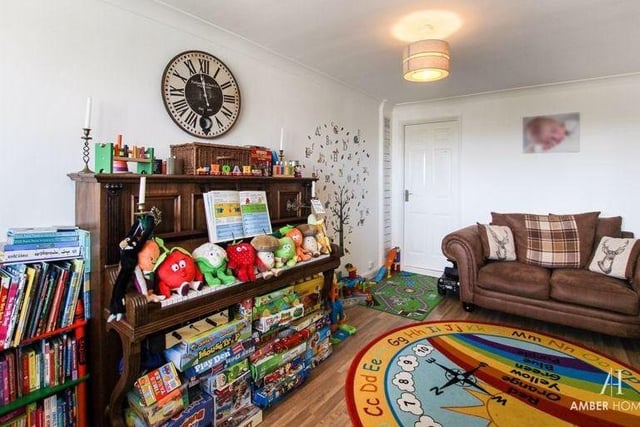 The playroom from a different angle. It has laminate flooring, plus a double-glazed window to the front of the Erica Drive house. The room also boasts access to the utility room and an under-stairs storage cupboard.