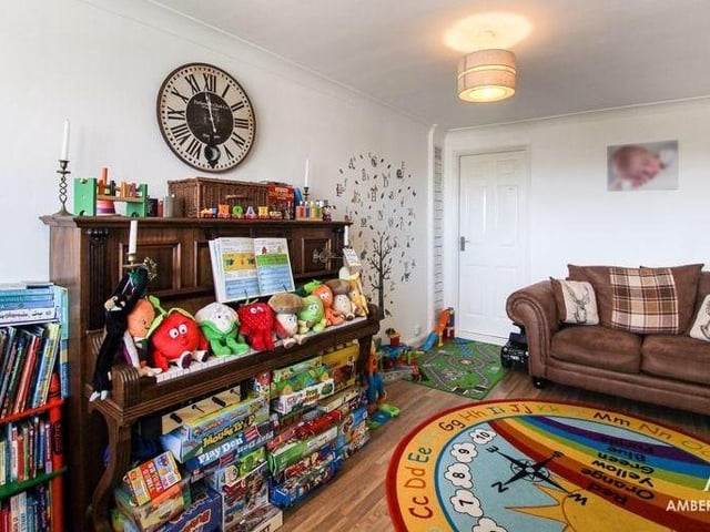 The playroom from a different angle. It has laminate flooring, plus a double-glazed window to the front of the Erica Drive house. The room also boasts access to the utility room and an under-stairs storage cupboard.