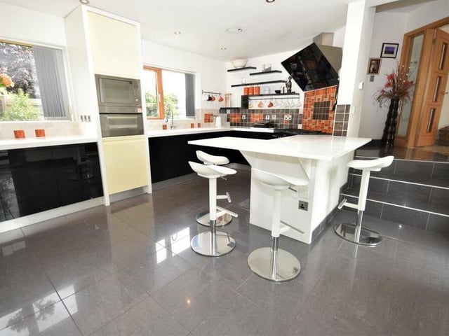 Steps lead down into the brilliant breakfast kitchen, where high-end appliances include a Rangemaster multi-oven range, with five-ring gas hob, hot plate and extractor above, combination microwave, coffee machine, fridge, freezer and dishwasher. Bright and light, the room has two windows to the front of the house and double doors leading outside.