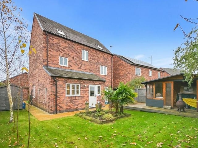 This view from the back garden shows the house looking just as impressive from the back as the front. To the side on the left is a shed and bin storage area.