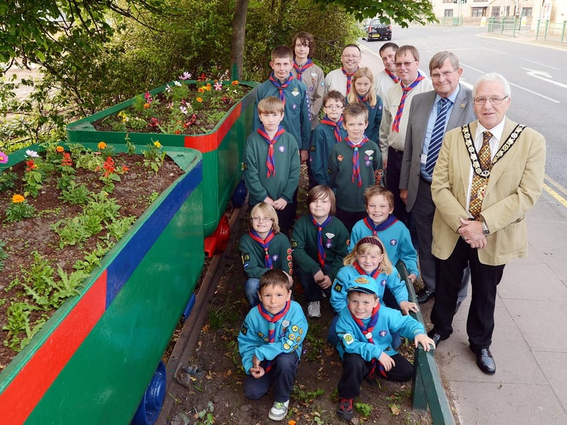 Members of the 2nd Warsop Cubs, Scouts and Beavers are pictured with councillors Derek Evans and John Kerr with the refurbished tubs that they painted and planted up in 2013.