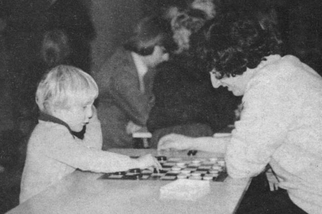 Volunteer playing draughts at a youth club in the Foxhill area in 1973