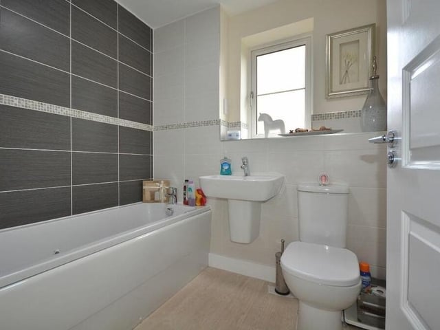 The family bathroom on the first floor is a modern suite that consists of a panelled bath with chrome mixer tap, wall-hung wash hand basin, low-flush WC, chrome, heated towel-rail, tiled display shelf and vinyl floor.