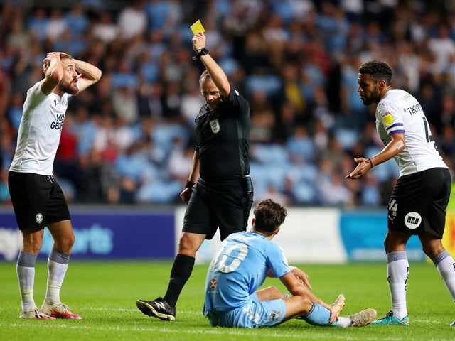 Referee Geoff Eltringham shows a yellow card to Dan Butler against Coventry City. Posh have had 80 bookings and two red cards this season.