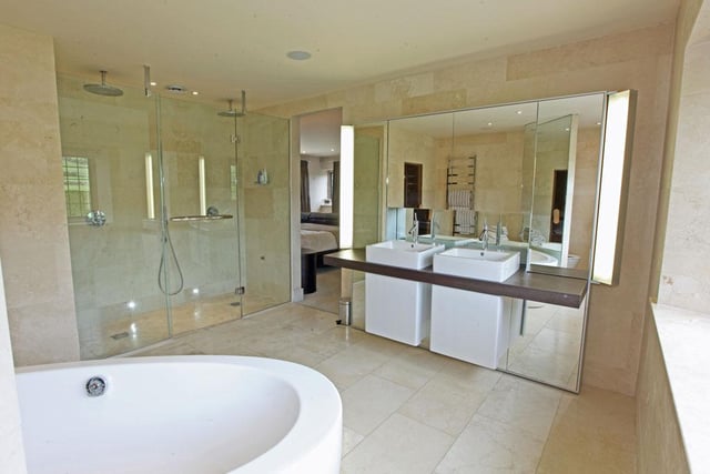 A huge bathroom suite comprising bath, large twin shower, w.c., twin hand basins and built-in sauna.