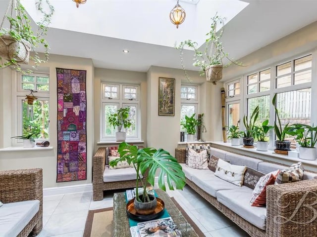 Featuring  tiled flooring, downlights, lantern roof window with lighting, underfloor heating, surrounding windows and French doors leading to pergola covered patio seating area and garden.