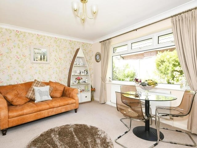 A close-up of the dining area, with its carpeted floor and space for both a sofa and dining table. The window faces the back of the bungalow.