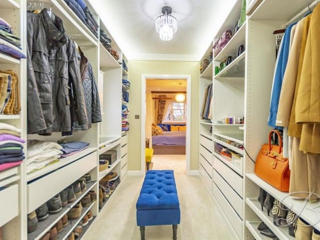The master bedroom has access to this impressive walk-in wardrobe, complete with fitted shelving and drawers.