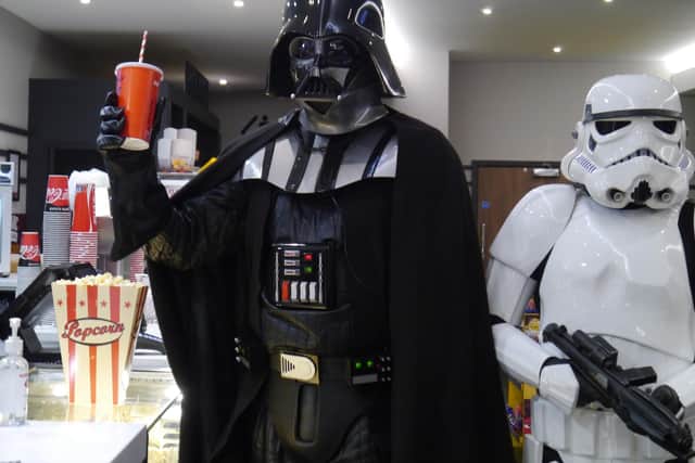 Darth Vader and a Stormtrooper stock up on treats during the Star Wars fan event