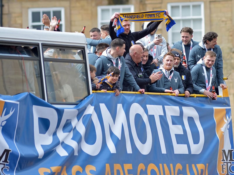 Players and staff wave from the bus.
