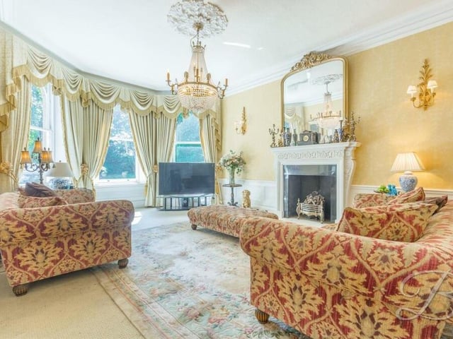 Our tour of the spectacular Crow Hill Drive property begins in this stunning living room. It boasts an attractive feature fireplace and a formidable bay window that faces the front of the house and allows a wealth of natural light through.