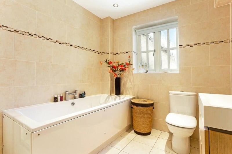 The family bathroom, which sits at the end of the first floor, is fully tiled. It comprises a fitted bath, quadrant shower cubicle, low-level WC, vanity wash hand basin and chrome heated towel-rail.