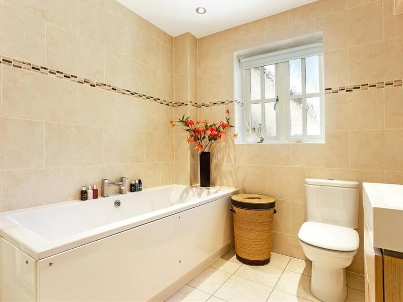 The family bathroom, which sits at the end of the first floor, is fully tiled. It comprises a fitted bath, quadrant shower cubicle, low-level WC, vanity wash hand basin and chrome heated towel-rail.