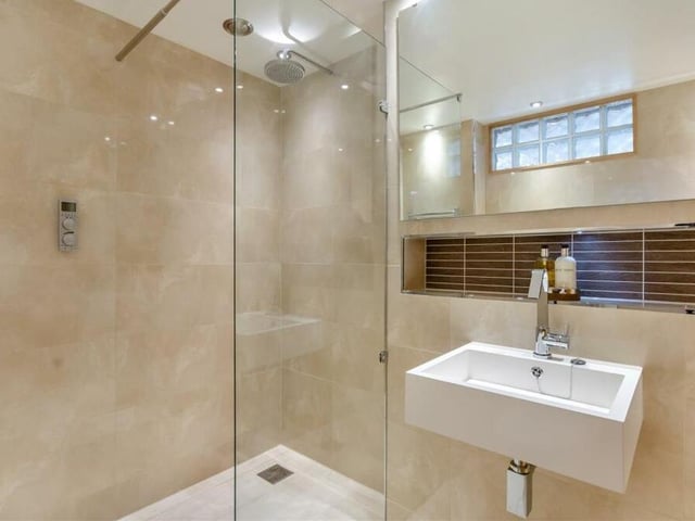 This wonderful en suite wet room belongs to the second bedroom. A walk-in shower has a remote-controlled Grohe rainfall shower, complemented by a wall-hung wash hand basin and low-flush WC. Porcelain-tiled flooring and walls, plus ceiling spotlights and underfloor heating add to the room's appeal.
