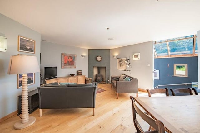 The property is spread over three floors, with the five bedrooms on floor one. Floor two houses the main reception rooms, including this dining and living area, complete with feature fireplace.