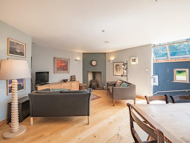 The property is spread over three floors, with the five bedrooms on floor one. Floor two houses the main reception rooms, including this dining and living area, complete with feature fireplace.