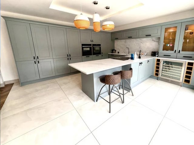 Fitted with contemporary wall and base units and a full range of integrated Neff appliances, including double ovens, microwave, warming drawer, double fridge/freezers, dishwasher, and wine cooler.