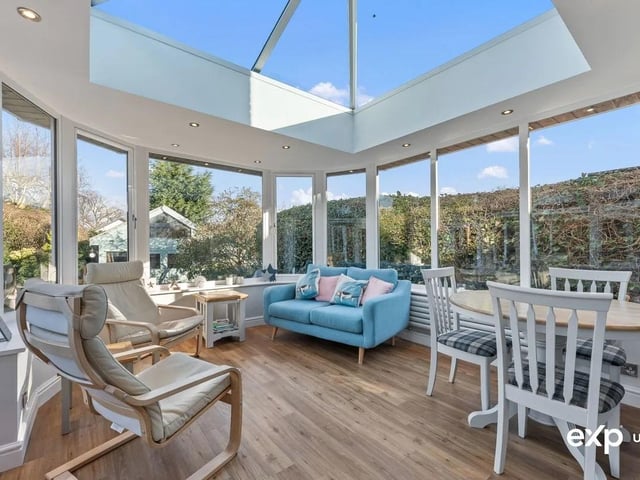 This breath-taking room is the most beautiful bright space, catching maximum sunlight, creating a tranquil atmosphere. It is a quite spectacular bespoke design, featuring a ceiling lantern, sleek oak effect flooring, and walls of windows that gaze out to a vista of captivating views of the garden. Carefully planned and built with all of the seasons in mind, the Orangery is fully insulated, with thermostatically controlled under floor heating making it a luxurious all year round space. There is also a column radiator. Internal and external down lighting add to the ambience. Double doors open to the patio and beyond, seamlessly connecting with the outdoors.