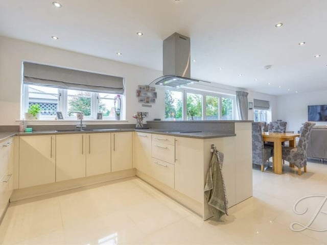 The high-quality kitchen boasts a range of gloss wall and base units with complementary worktop over, inset sink and drainer with mixer tap. There is a hob with stainless steel extractor fan above, integrated dishwasher, breakfast bar, underfloor heating, downlights and space for a double fridge/freezer.