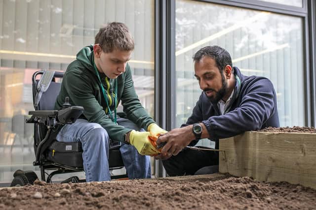 Student Connor Yardley screws the wooden planters together with lead mentor Sajid Mahmoud
