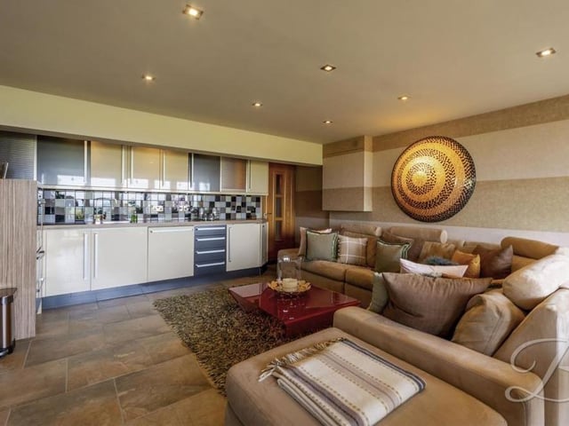 Attached to the living space in the garden room is this second kitchen, with built-in oven, inset sink and matching units, making it a multi-purpose area ideal for cooking and entertaining.