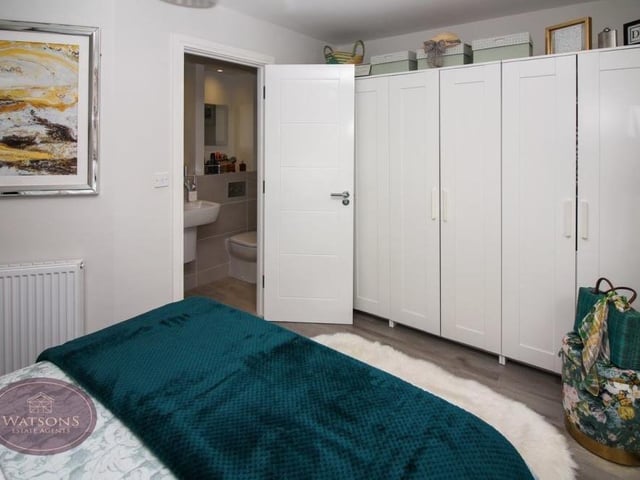 The primary bedroom has space for wardrobes, while the door leads to an en suite bathroom.
