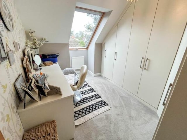 This is one of three bedrooms that contains a fitted desk or dressing table.