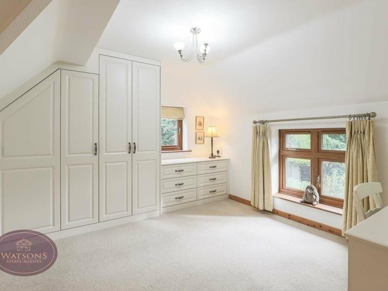 Extensive wardrobes are an eyecatching feature of the dressing room within the main bedroom. They are part of a range of matching, fitted furniture.
