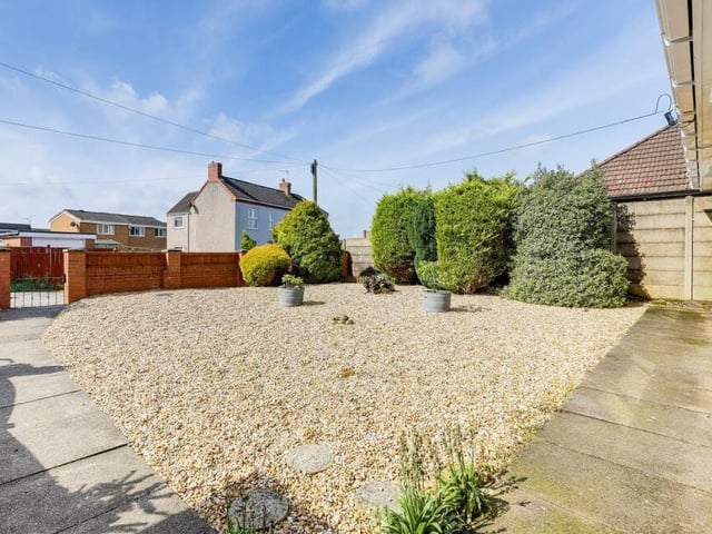 The last image in our gallery returns to the front of the property and focuses on a low-maintenance garden with gravelled area, established shrubs and gated access to the bungalow.