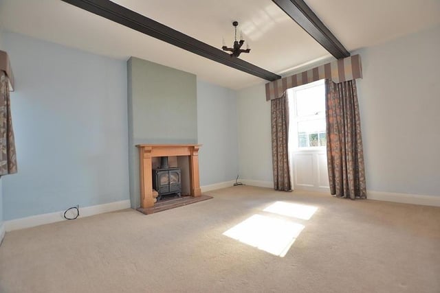 The attractive lounge has a fireplace with an inset multi-fuel stove, quarry-tiled hearth and wood surround. There are windows to the front and side.