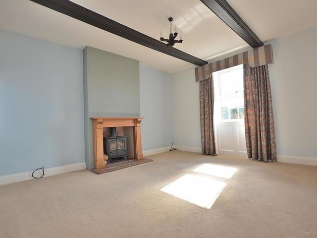 The attractive lounge has a fireplace with an inset multi-fuel stove, quarry-tiled hearth and wood surround. There are windows to the front and side.