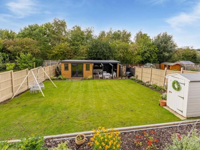 The top two tiers of the garden have steps that lead down to a well-maintained and spacious lawn, which has a summer house at the far end. There is also a storage shed and a collection of beautiful, decorative shrubs.