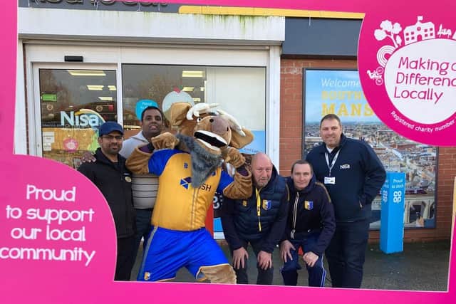 Coaches and mascot visit Prem's service station store.