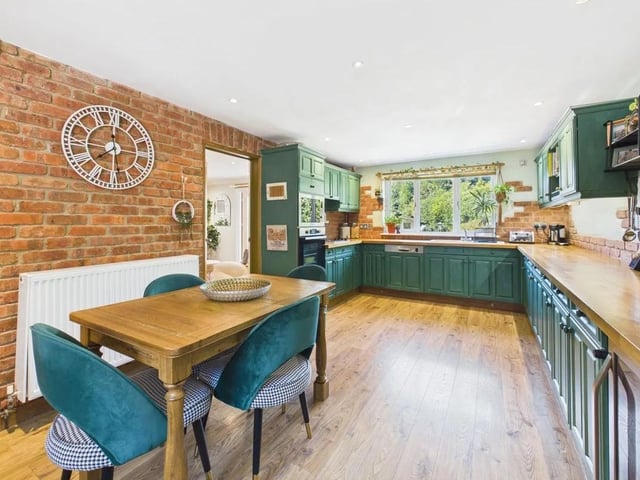 The suite of integrated appliances includes an electric oven, hob, microwave, dishwasher and wine cooler, alongside dedicated space for a washing machine and tumble dryer.
