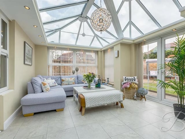 The garden room is a tranquil space with high ceilings and surrounding windows.