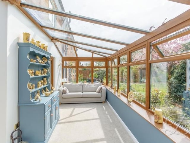 Here is the second conservatory at the Kirkby barn conversion. It has a carpeted floor and surrounding windows.