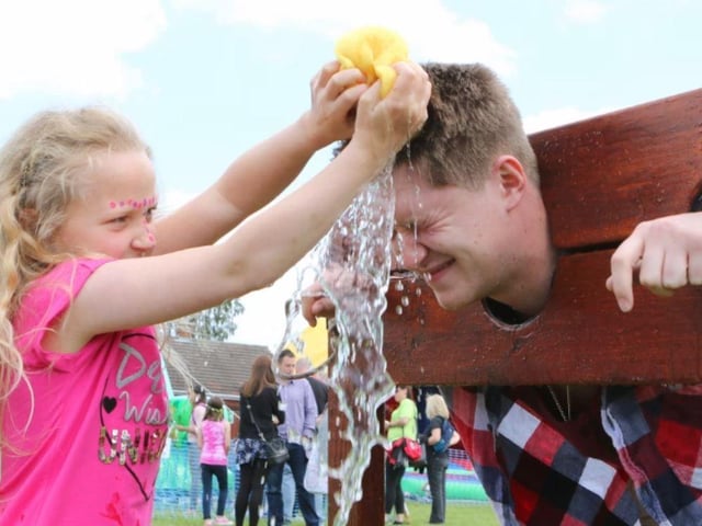 Zara Baker gives big brother Adam a soaking in the stocks at the Ravenshead Primary School summer festival.