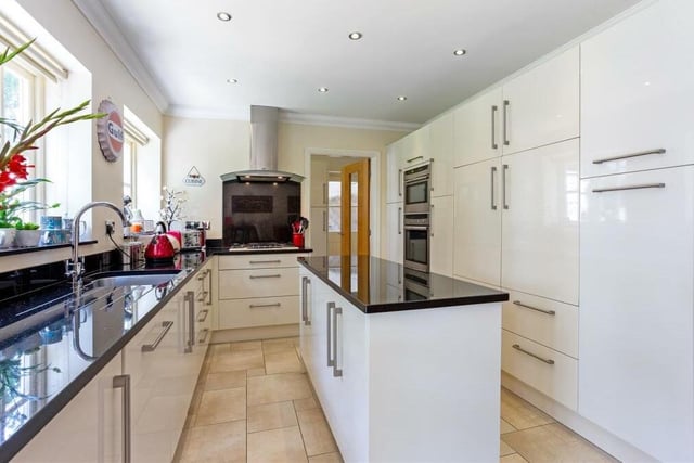 On now to the sleek kitchen and breakfast room, which is fitted with modern cabinets and units, work surfaces and an inset sink with mixer tap. Integrated appliances include a gas hob, extractor fan, oven, microwave, fridge freezer and dishwasher, while a tiled floor and downlights add style.