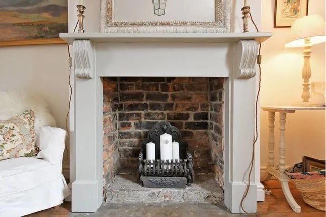 The lounge has neutral tones and a focal decorative fireplace, painted with Farrow & Ball paint.