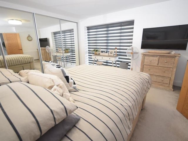 This second shot of the main bedroom shows off its range of fitted, mirrored wardrobes, which add a bespoke, boutique feel to the room.